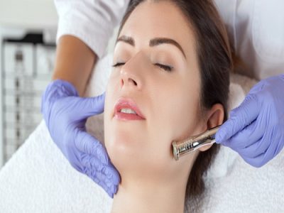 The cosmetologist makes the procedure Microdermabrasion of the face skin of a beautiful woman in a beauty salon.Cosmetology and professional skin care.